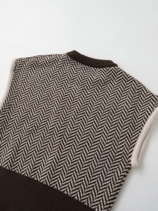 Close-up of herringbone knit pattern on retro vest with ribbed crewneck detail