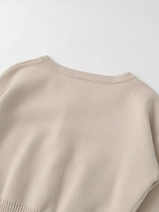 Detailansicht des beigen Strickpullover-Ausschnitts und der feinen Stoffstruktur