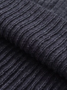 Vue macro montrant la texture douce et les détails en maille côtelée du pull gris foncé