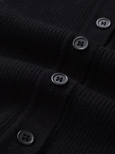 Macro view of black ribbed knit fabric texture and sleek four-hole button detail