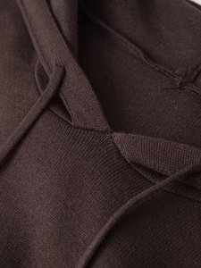 Detailed view of dark brown knitted hoodie showing ribbed texture and drawstring design