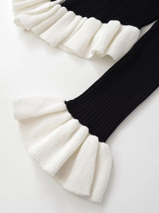 Détails de volants superposés contrastés et maille côtelée sur un cardigan noir et blanc