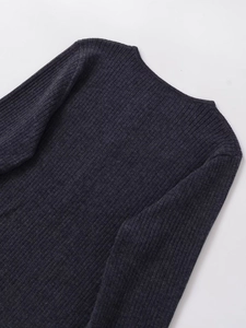 Gros plan détaillé de la texture en maille côtelée gris foncé d'un pull à manches longues