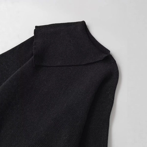 Elegant black knit poncho sweater with a large turtleneck and textured knit weave finish
