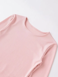 Détail du tissu en maille côtelée rose et couture d'encolure sur un t-shirt à manches longues