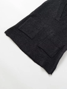 Close-up of charcoal grey V-neck knit vest with front patch pockets and ribbed hem
