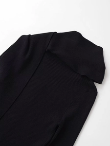Close-up detail of black ribbed knit sweater with elegant scarf collar design