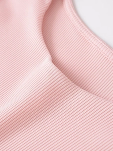 Détail de la texture en maille côtelée rose et des finitions de couture sur un haut souple