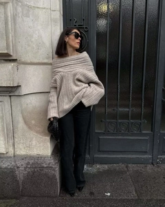 Detailed close-up of oatmeal ribbed knit off-the-shoulder sweater with high-quality texture