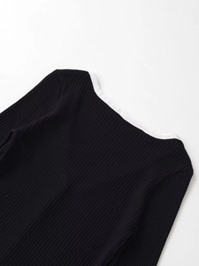 Détail du cardigan en maille côtelée noire avec liseré blanc contrastant au col