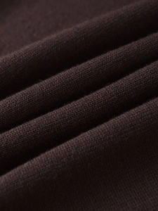 Macro texture of soft dark coffee knit fabric showing premium fiber density and weave
