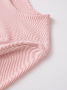 Gros plan du tissu en maille côtelée rose clair montrant les coutures et la texture