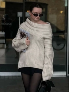 Detailed texture of off-white ribbed knit sweater featuring an off-shoulder neckline