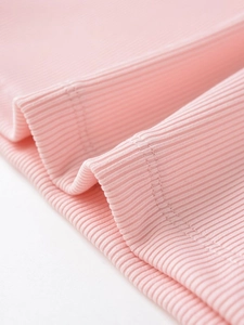 Gros plan sur le tissu côtelé rose clair avec double couture de qualité sur l'ourlet