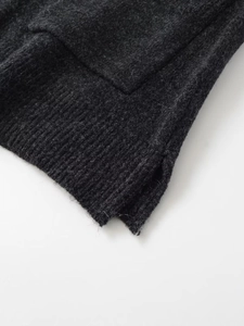 Close-up of ribbed hem and side slit detail on dark grey knit sleeveless vest