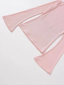 Vue détaillée du tricot côtelé rose clair avec des manches longues évasées élégantes