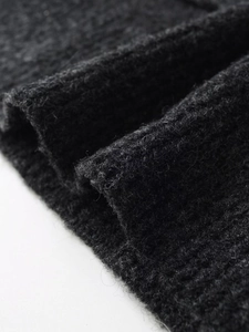 Macro shot of dark grey ribbed knit fabric showing soft wool texture and fine craftsmanship