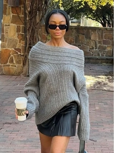 Detail of grey off-shoulder knit sweater showing thick vertical ribbed texture and loose fit