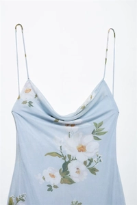 Detail of light blue floral dress showing thin spaghetti straps and elegant cowl neck