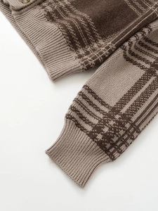 Close-up of ribbed cuffs and plaid pattern on brown and beige knit cardigan with button