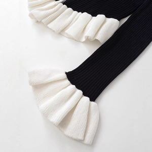 Cardigan noir en maille côtelée avec poignets à volants blancs superposés chic