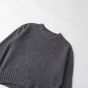Minimalist dark grey crewneck sweater with ribbed knit details and dropped shoulders
