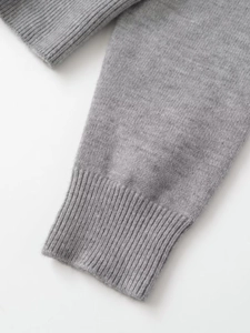 Detail view of the fine knit texture and ribbed cuffs on a grey hooded cardigan