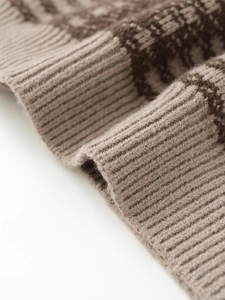 Close-up of khaki plaid knit fabric showing detailed ribbed cuffs and thick texture