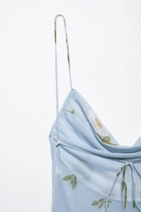Detail of light blue floral print dress with thin straps and draped neckline design