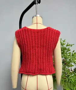 Detail of red chunky knit vest showing vertical rib texture and thick yarn material