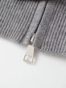 Detailed macro view of grey ribbed knit texture with a silver metal zipper slider