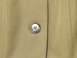 Makroaufnahme einer khakifarbenen Twilljacke mit mattem Knopf und verstärkten Nähten