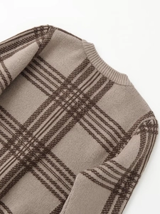 Detailed close-up of ribbed crewneck and brown plaid knit pattern on the warm sweater