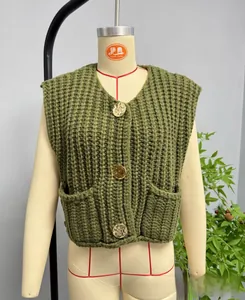 Detail of dark green knit vest featuring textured vertical stripes and gold embossed buttons