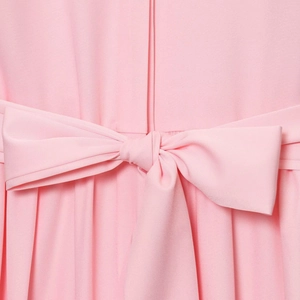 Detailed view of the pink shirt dress featuring a waist belt bow and pleated texture