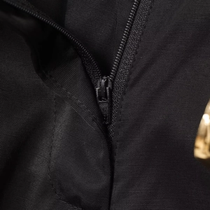 Gros plan sur la fermeture éclair en métal noir avec logo sur le pantalon large en satin