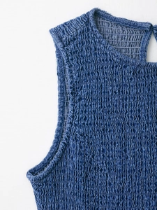 Vista dettagliata della texture denim a nido d'ape e della scollatura di questo abito blu
