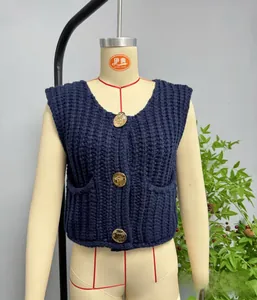 Close-up of navy blue chunky knit vest with vintage gold buttons and cable patterns