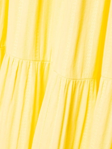 Dettaglio dell'abito giallo con schiena scoperta in jacquard a strati con volant