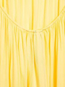 Dettaglio del tessuto giallo brillante con grana verticale e design dello scollo arricciato