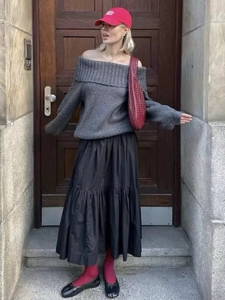 Street style view of grey off-shoulder knit sweater with layered black skirt and red bag