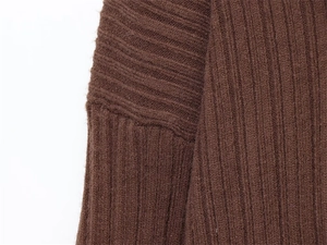 Detail of brown ribbed knit texture and shoulder seam on an off-shoulder sweater