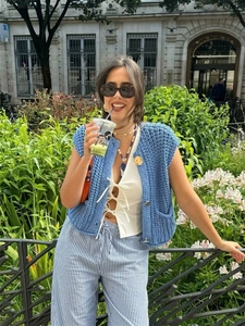 Chic blue chunky knit vest with gold buttons and striped trousers in street style