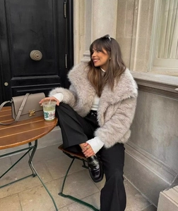 Dettaglio di cappotto in pelliccia sintetica grigia con dolcevita bianco elegante