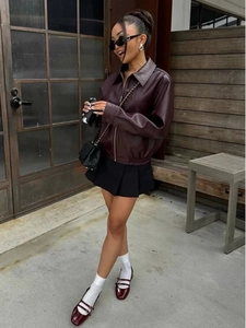 Foto street style di una giacca in ecopelle bordeaux con colletto a revers e zip