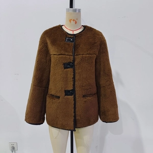 Detail of faux fur brown coat with black leather piping and round buttons