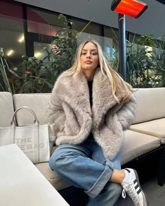 Dettaglio della trama del cappotto in ecopelliccia beige con ampio collo a revers
