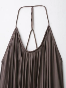 Gros plan détaillé sur la texture plissée marron foncé de la robe en satin