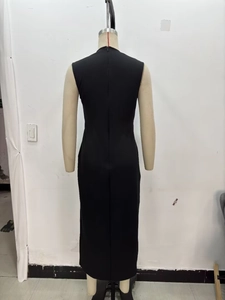 Detail view of the long invisible zipper on the back of a black sleeveless midi dress