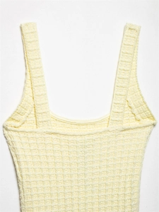 Detailaufnahme eines hellgelben Strickkleids mit Waffelstruktur und feiner Rippkante